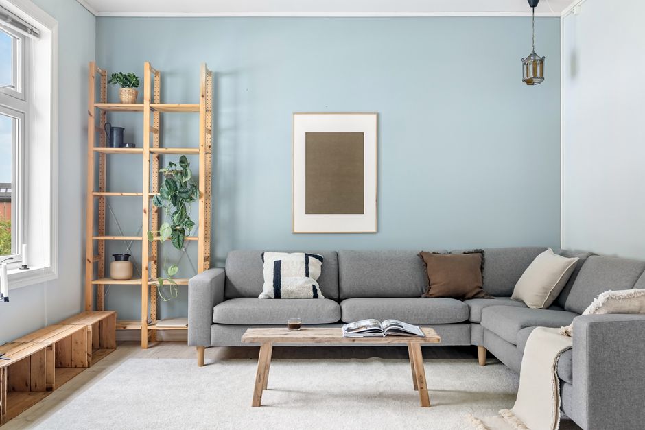 A cozy Scandinavian living room with modern gray couch and wooden elements.